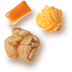 A picture of two kernels flavored Caramel & Cheddar Cheese next to a chuck of Caramel.