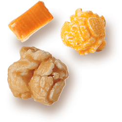 A picture of two kernels flavored Caramel & Cheddar Cheese next to a chuck of Caramel.