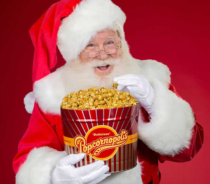 Santa eating caramel popcorn from a tin