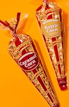 Picture of five gourmet mini cones flavored of Caramel Corn and Kettle Corn. With orange background.
